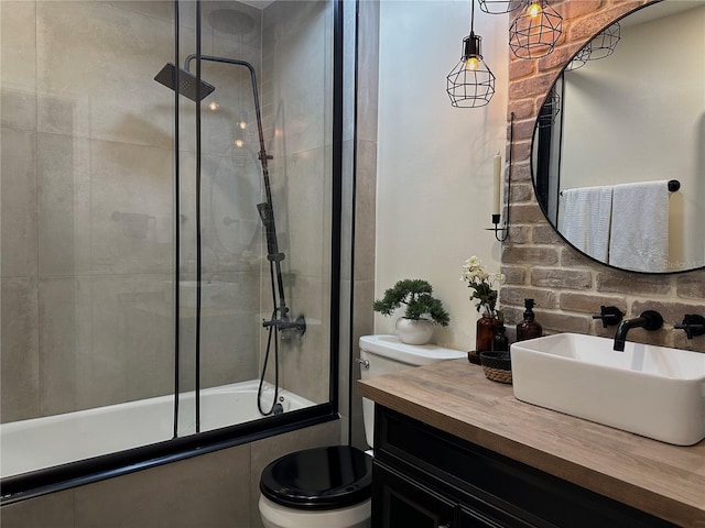 bathroom with shower / bath combination with glass door, vanity, and toilet