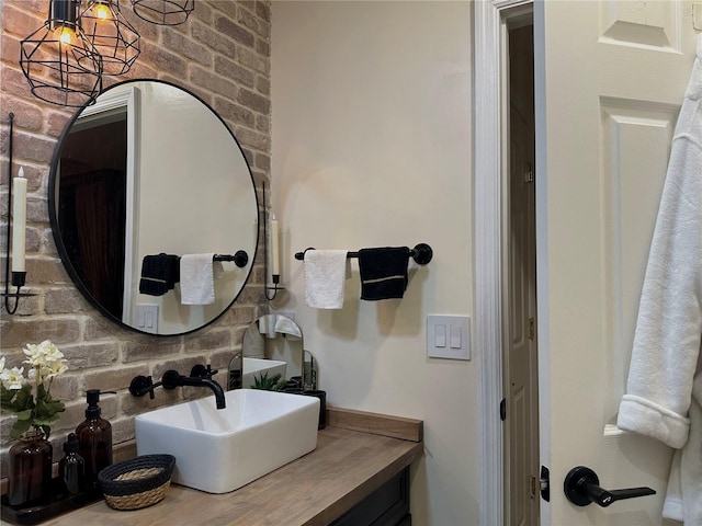 bathroom with brick wall and vanity