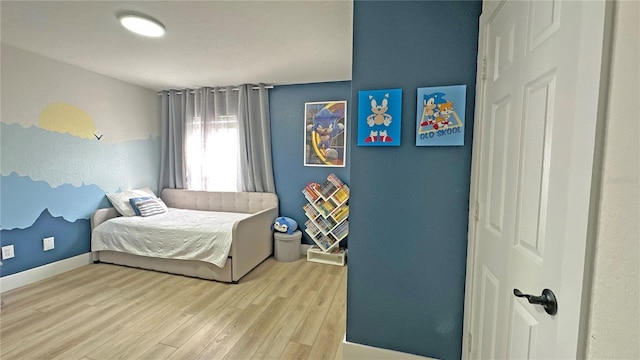 bedroom featuring baseboards and wood finished floors