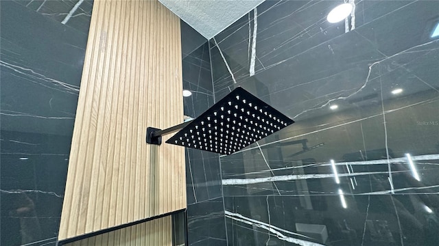 interior details with tiled shower and a textured ceiling