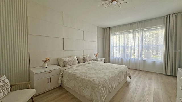 bedroom with light wood-style floors and a textured ceiling