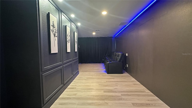 corridor featuring vaulted ceiling, light wood-type flooring, visible vents, and recessed lighting