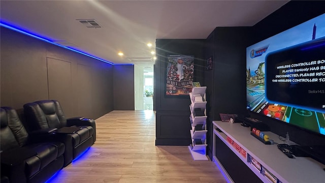 cinema room with visible vents and light wood-style flooring