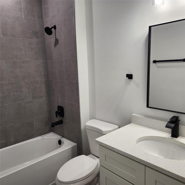 bathroom with toilet, a textured wall, vanity, and washtub / shower combination