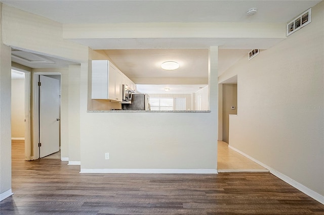 kitchen with visible vents, appliances with stainless steel finishes, wood finished floors, and white cabinetry