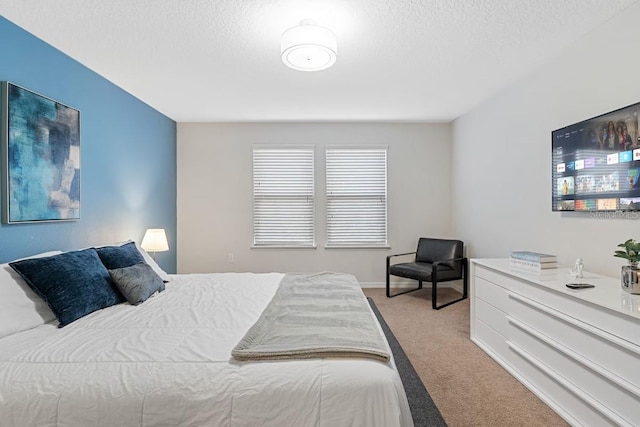 bedroom with light carpet and a textured ceiling