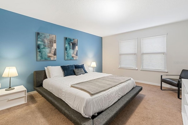 bedroom featuring light carpet and baseboards