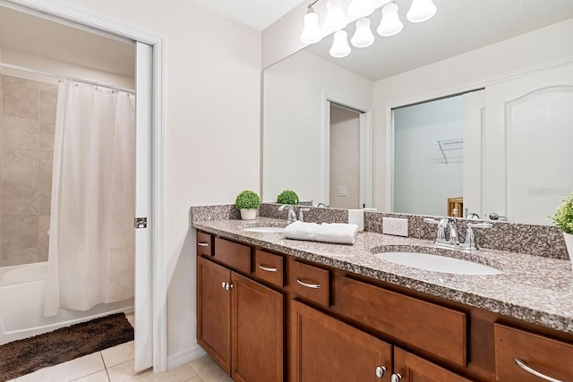 full bath featuring tile patterned flooring, a sink, a spacious closet, and double vanity