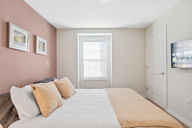 bedroom with a textured ceiling and baseboards