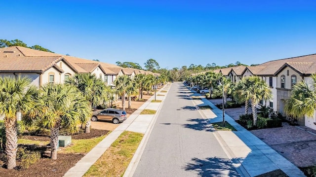 view of road with sidewalks, a residential view, and curbs