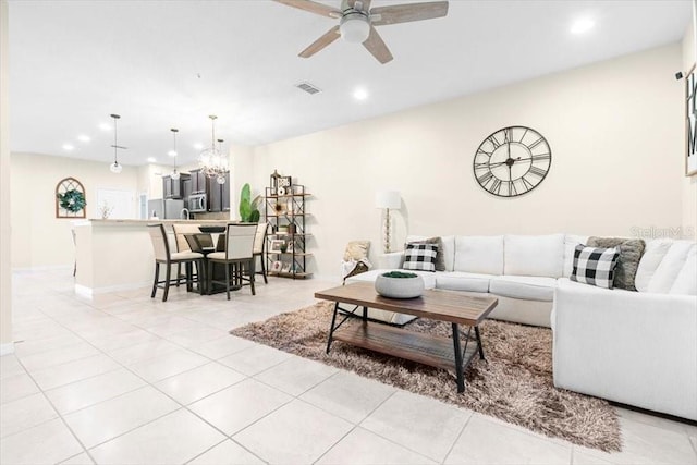 living area with light tile patterned floors, ceiling fan with notable chandelier, visible vents, and recessed lighting