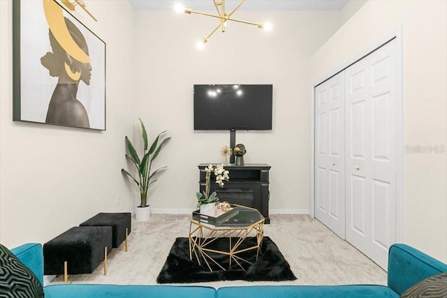 living area featuring a chandelier, carpet, and baseboards