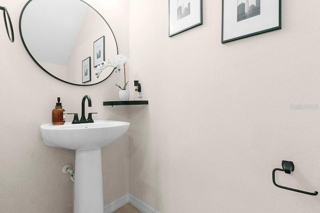 bathroom with a sink and baseboards