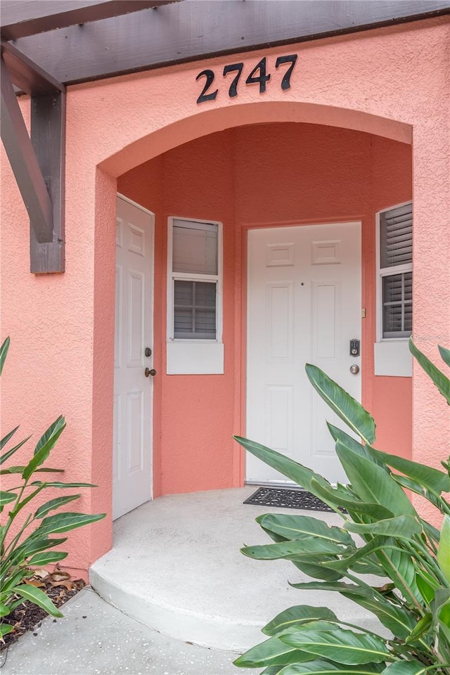 doorway to property featuring stucco siding