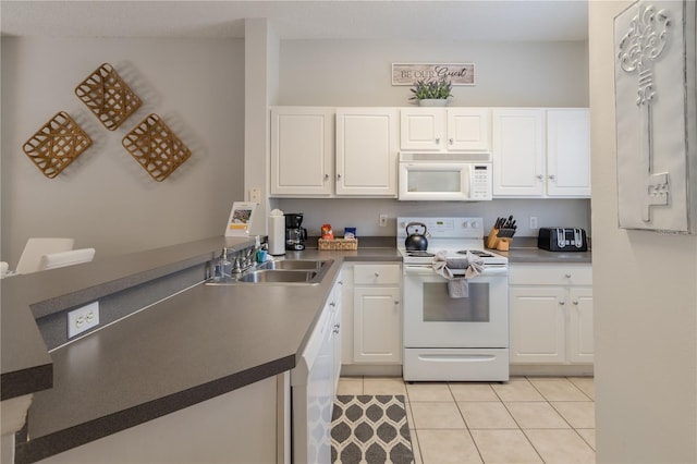 kitchen with light tile patterned floors, white appliances, a sink, and white cabinetry