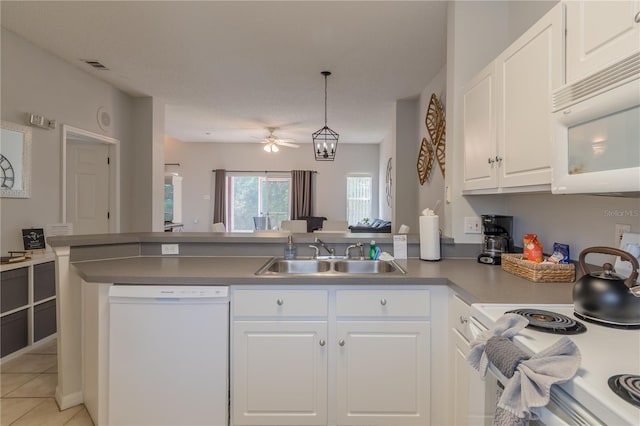 kitchen with visible vents, white cabinetry, a sink, white appliances, and a peninsula