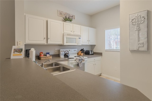 kitchen featuring white appliances, light tile patterned flooring, a sink, and white cabinetry