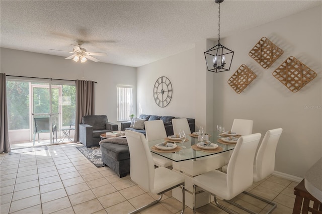 dining space featuring ceiling fan with notable chandelier, a textured ceiling, baseboards, and light tile patterned floors