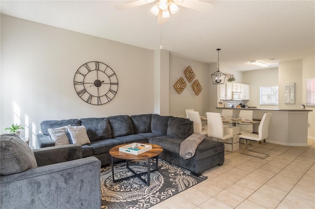 living room featuring a textured ceiling, a ceiling fan, and light tile patterned flooring