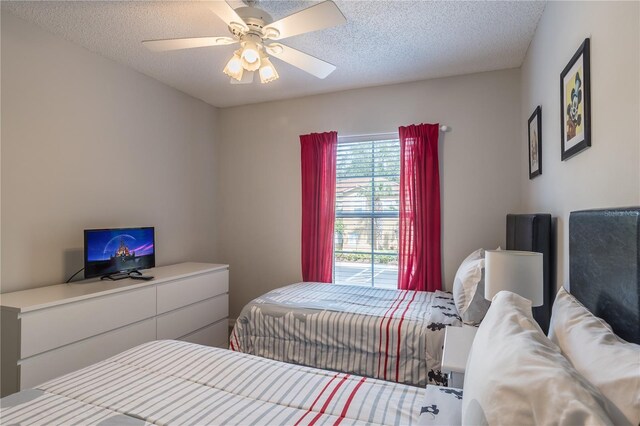 bedroom with a ceiling fan and a textured ceiling