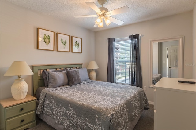 bedroom with ceiling fan, dark carpet, and a textured ceiling