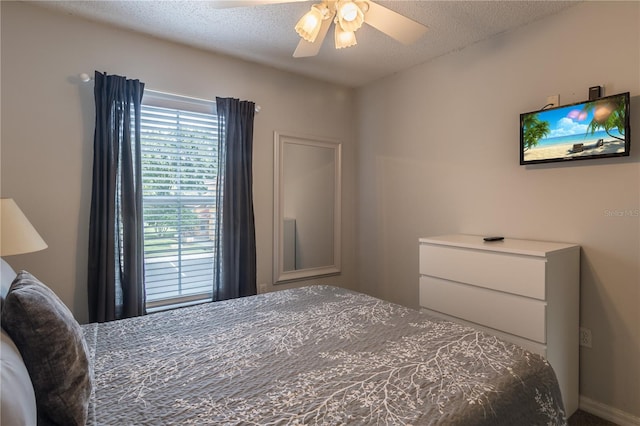 bedroom with a textured ceiling and a ceiling fan