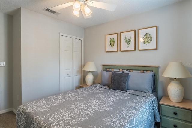 carpeted bedroom with a textured ceiling, a closet, visible vents, and a ceiling fan