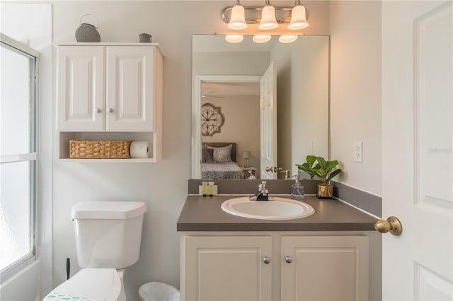 ensuite bathroom featuring vanity, toilet, and connected bathroom