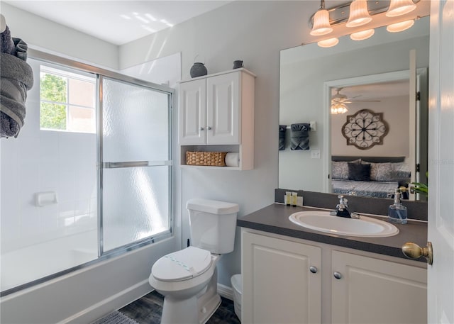 full bath featuring ceiling fan, toilet, vanity, combined bath / shower with glass door, and ensuite bath