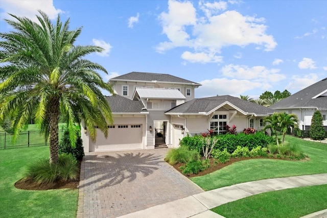 view of front facade with a garage, fence, decorative driveway, a front yard, and stucco siding