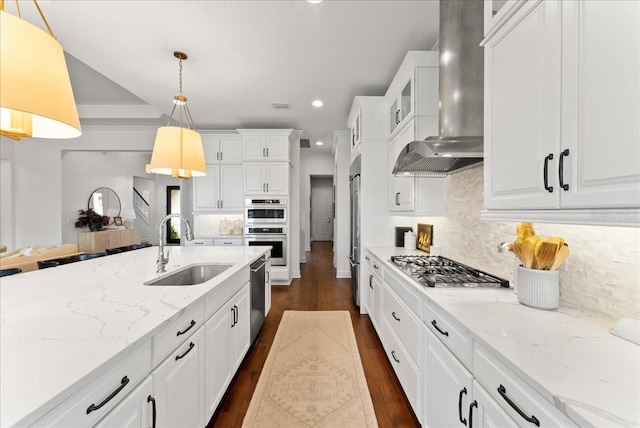 kitchen featuring wall chimney exhaust hood, white cabinetry, glass insert cabinets, and a sink