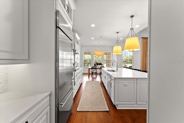 kitchen featuring white cabinets, a sink, and decorative light fixtures