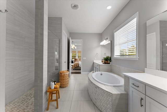 bathroom featuring tile patterned floors, connected bathroom, vanity, a textured ceiling, and walk in shower