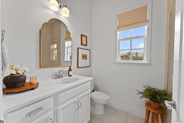 bathroom featuring baseboards, vanity, toilet, and tile patterned floors