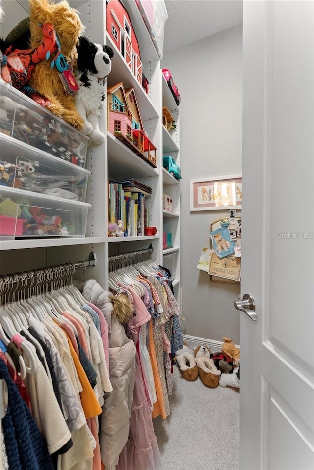 walk in closet featuring carpet flooring