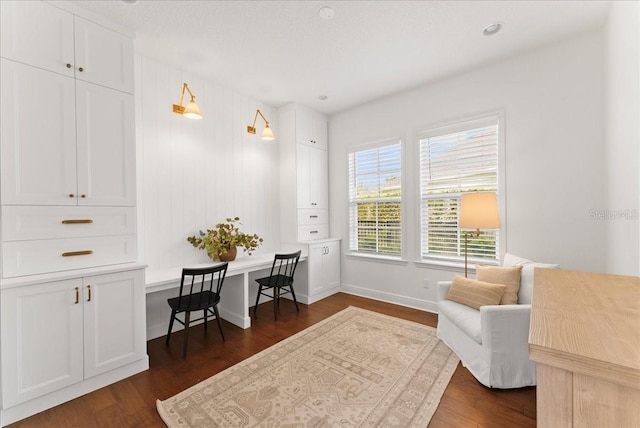 sitting room with dark wood finished floors and baseboards