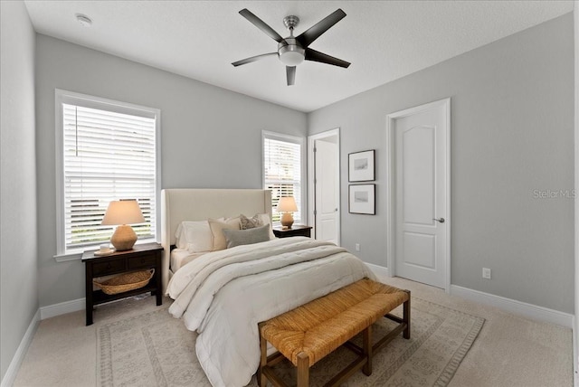 bedroom with multiple windows, baseboards, and light colored carpet