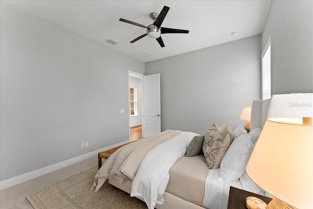 bedroom with a ceiling fan, carpet flooring, visible vents, and baseboards