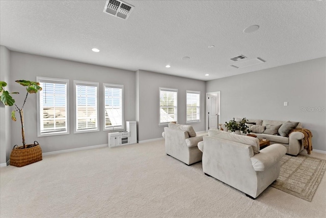 living area with light carpet, recessed lighting, visible vents, and baseboards