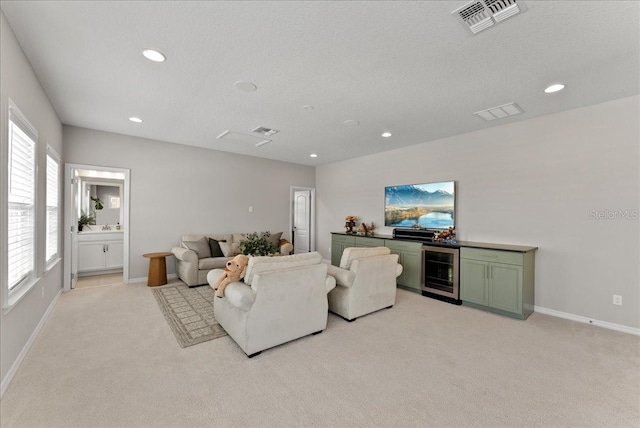 living room featuring beverage cooler, light carpet, visible vents, and recessed lighting