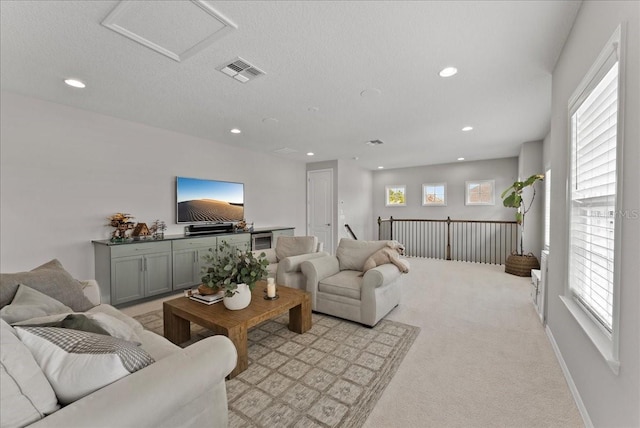 living area with light carpet, baseboards, visible vents, and recessed lighting