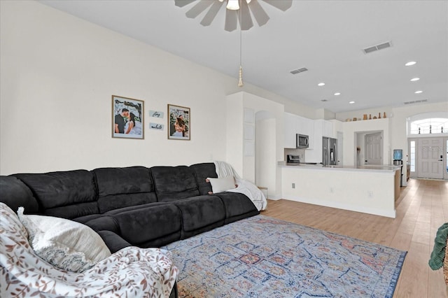 living room featuring light wood-style flooring, visible vents, a ceiling fan, and recessed lighting