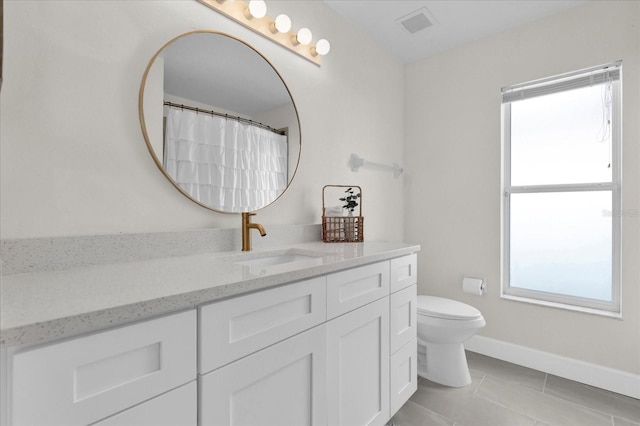 full bath featuring toilet, visible vents, vanity, baseboards, and tile patterned floors