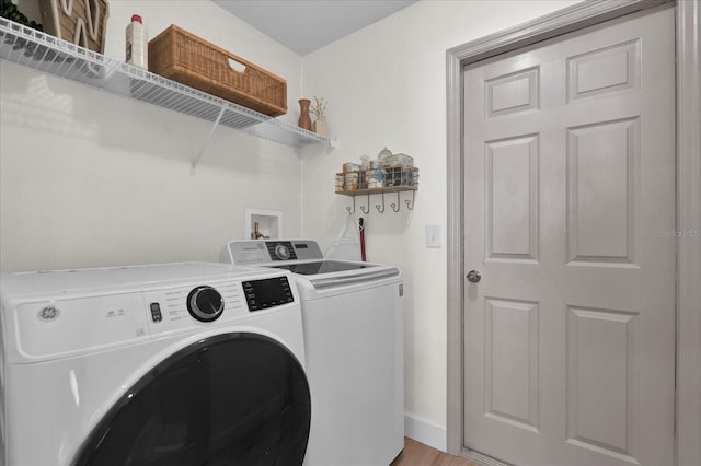 washroom featuring washer and dryer, laundry area, and baseboards