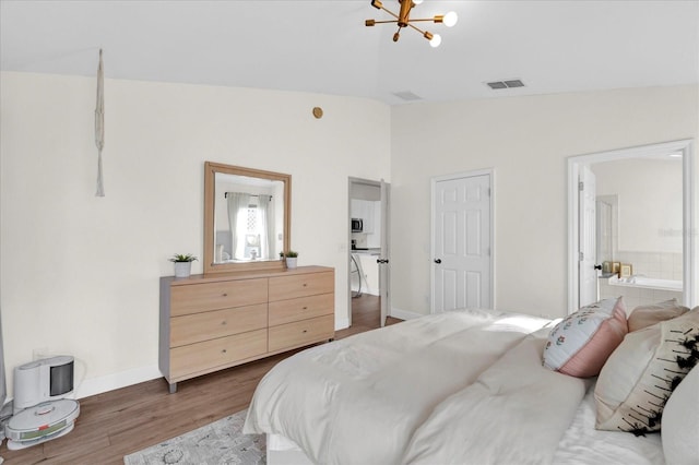 bedroom with baseboards, visible vents, lofted ceiling, wood finished floors, and a notable chandelier