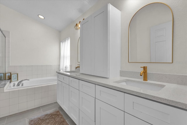 full bath featuring double vanity, a sink, a bath, and tile patterned floors