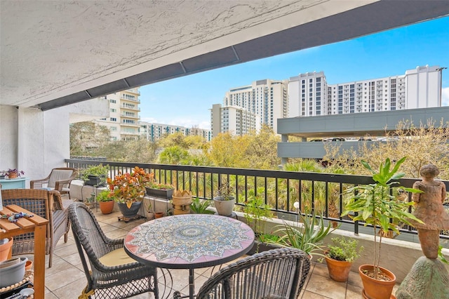 balcony with a view of city and outdoor dining space