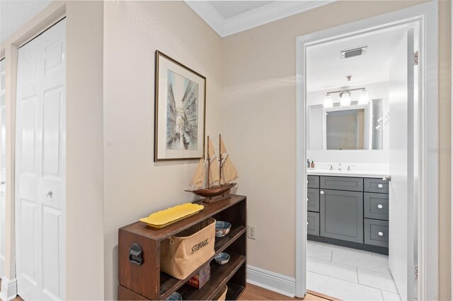 bathroom with vanity, visible vents, baseboards, ornamental molding, and tile patterned floors