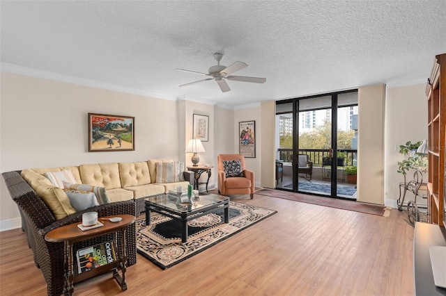 living area featuring baseboards, wood finished floors, crown molding, a textured ceiling, and floor to ceiling windows