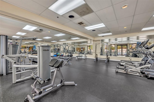 workout area with a paneled ceiling, visible vents, and baseboards